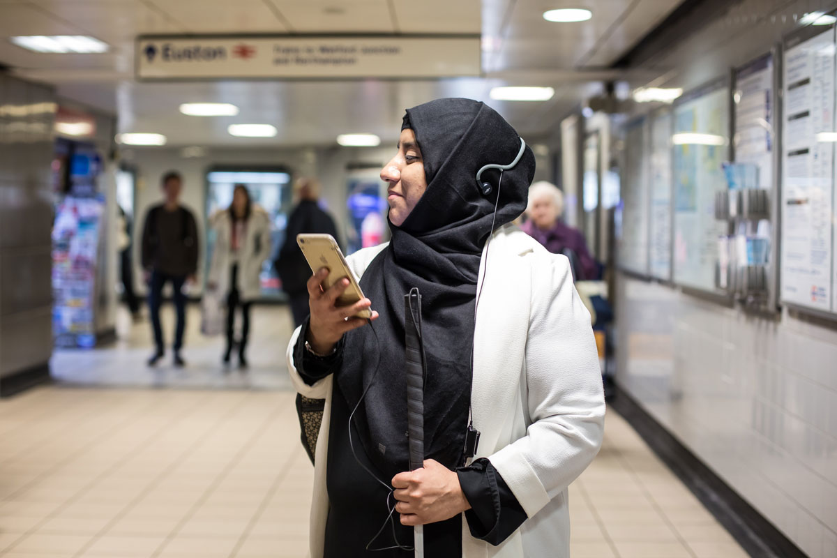 A vision impaired person trying out Wayfindr in a tube station