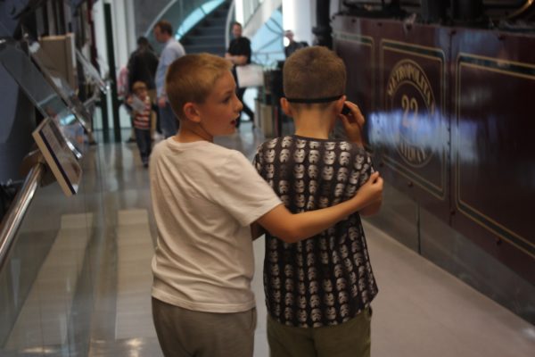 One boy guiding another through the London Transport Museum